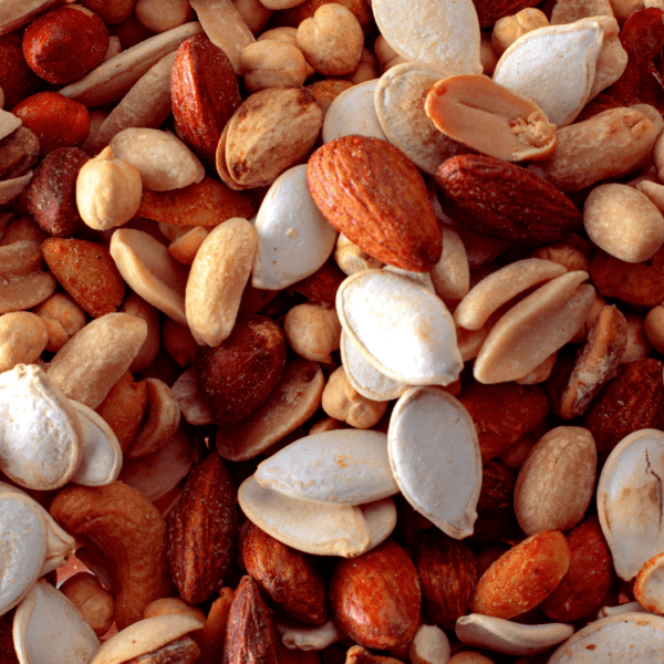A close-up of assorted nuts and seeds, including almonds, peanuts, cashews, pumpkin seeds, and chickpeas.