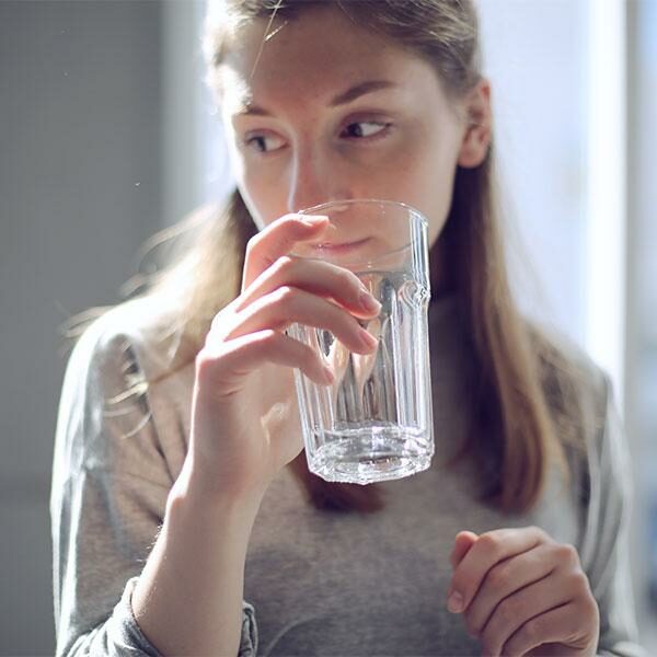 young woman drinking a glass of water