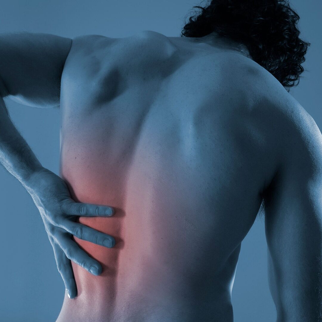 Shirtless man holding his back in pain