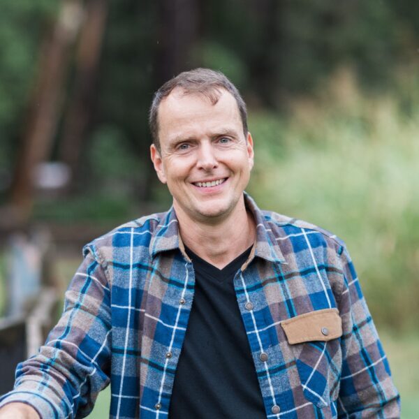 Aaron Hartman MD leaning against a fence at home