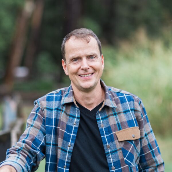 Aaron Hartman MD leaning against a fence at home