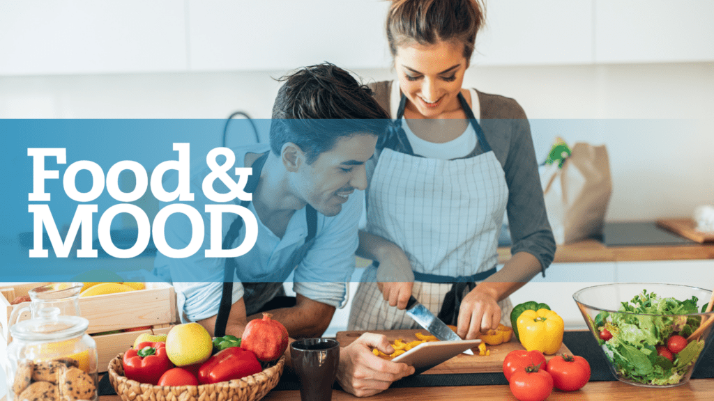 Man and Woman cooking in the kitchen with colorful vegetables and fruits