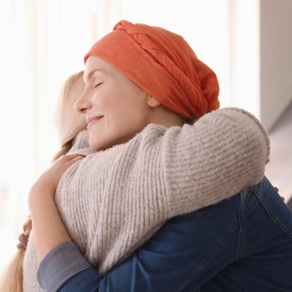 A Young woman with a head scarf hugging her mother