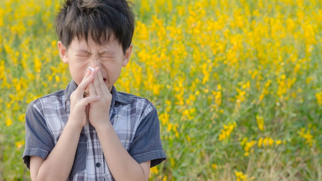 Little boy with allergies in a field of pollen