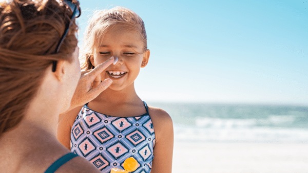 Mom putting sunscreen on a little girl