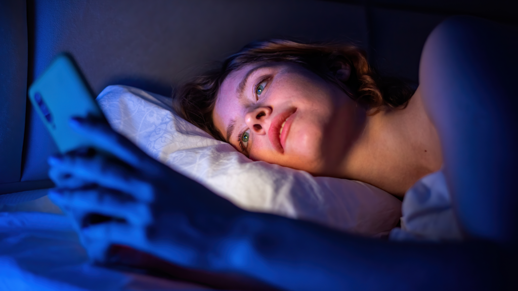 Woman using cellphone in bed before sleeping