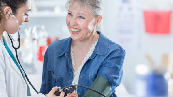 Doctor checks senior patient's blood pressure level