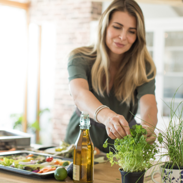 Woman preparing her own meal in the kitchen picking out some herbs