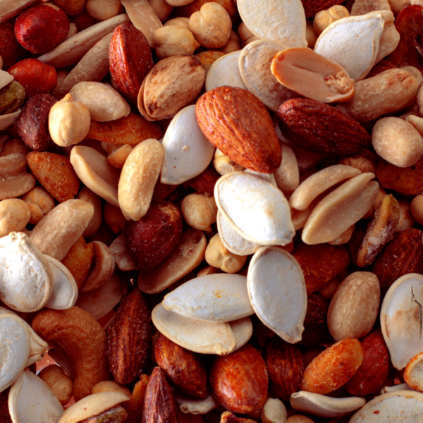 A close-up of assorted nuts and seeds, including almonds, peanuts, cashews, pumpkin seeds, and chickpeas.